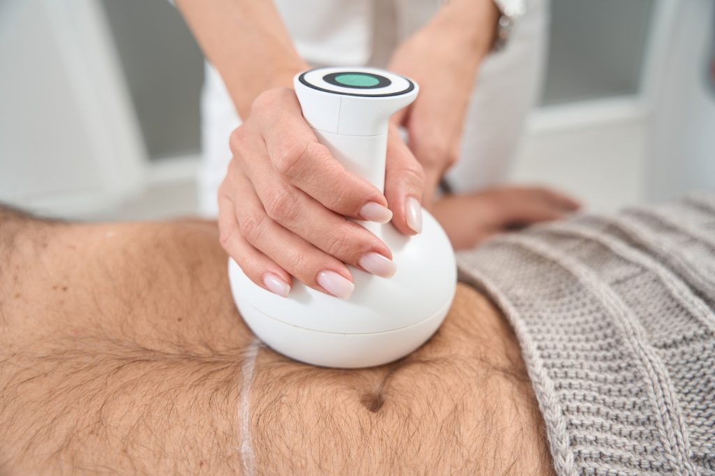 Body shaping specialist performs a procedure on a patient